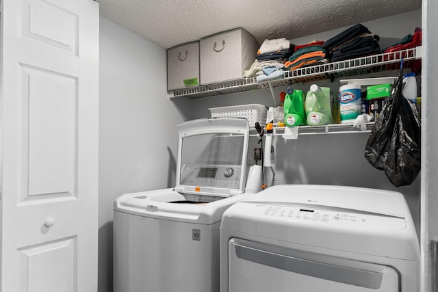 laundry room featuring separate washer and dryer and a textured ceiling