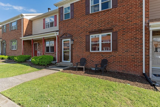 townhome / multi-family property featuring brick siding and a front yard
