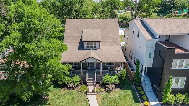 view of front of house with stairway, roof with shingles, a front yard, and a deck