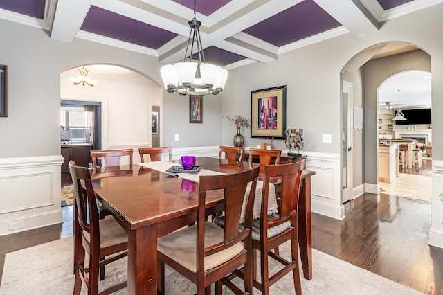 dining room with coffered ceiling, arched walkways, a chandelier, dark wood-style flooring, and beamed ceiling