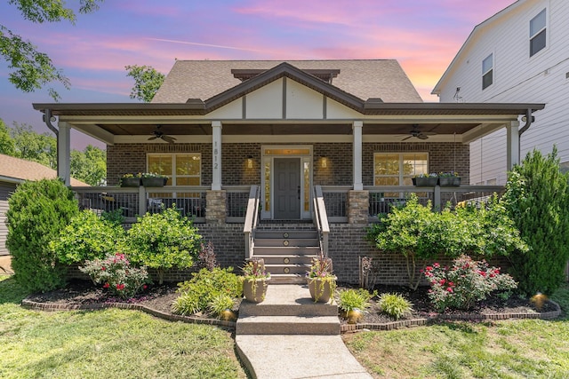 view of front facade with a ceiling fan, brick siding, and covered porch