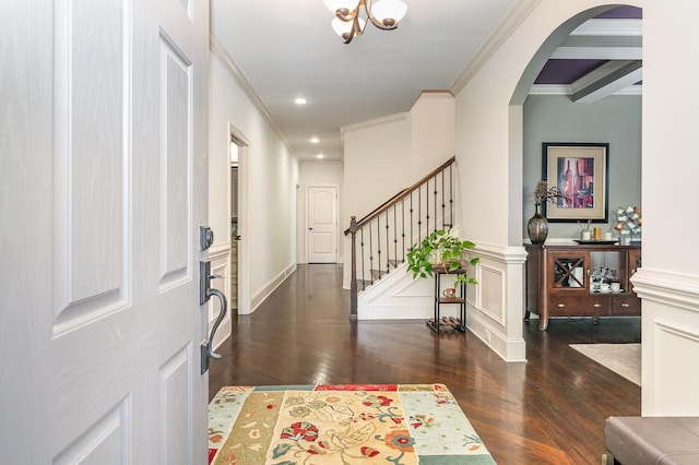 entryway with wood finished floors, ornamental molding, arched walkways, stairs, and recessed lighting