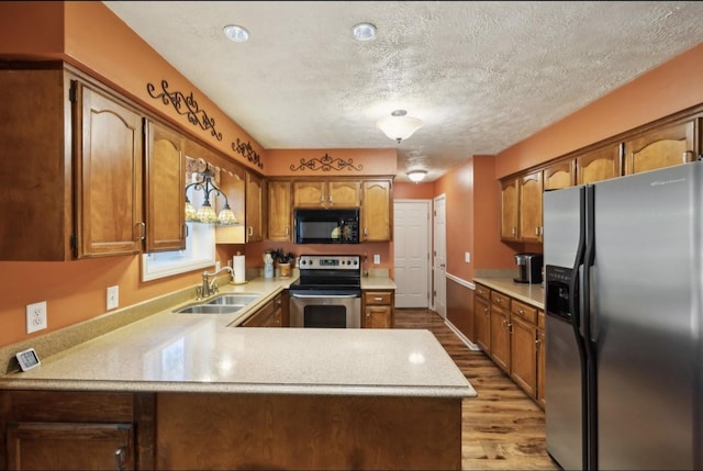 421 Robertson Dr, Smyrna, TN 37167 - kitchen featuring stainless steel appliances, a sink, a peninsula, light countertops, and light wood-style floors