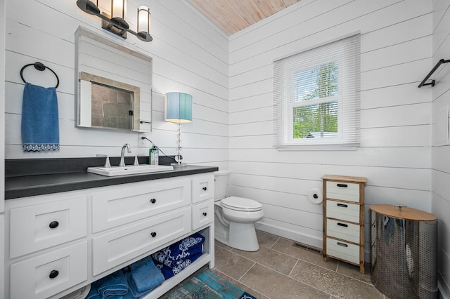61 Sunset Ct, Tracy City, TN 37387 - bathroom featuring wooden walls, vanity, and toilet