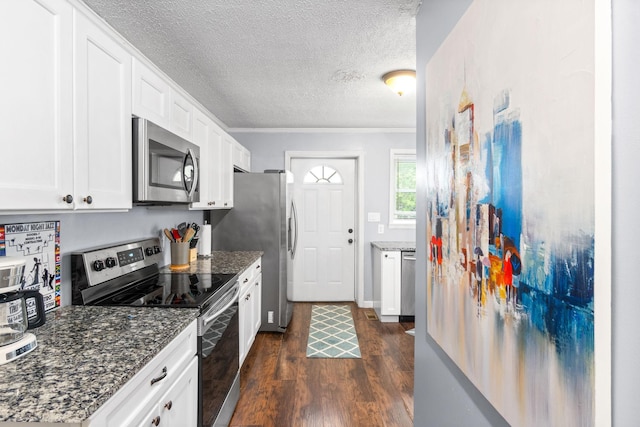 kitchen featuring stainless steel appliances, dark wood-type flooring, a textured ceiling, white cabinets, and dark stone countertops