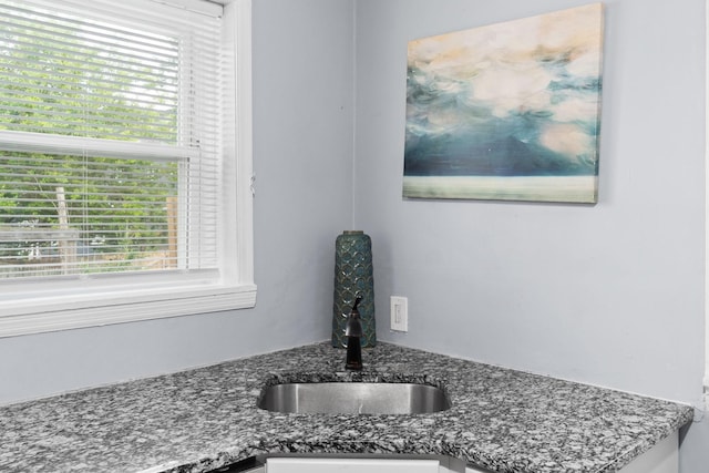 kitchen view of a sink and dark stone countertops