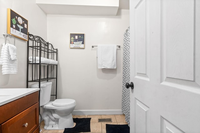 bathroom featuring toilet, vanity, tile patterned floors, and baseboards