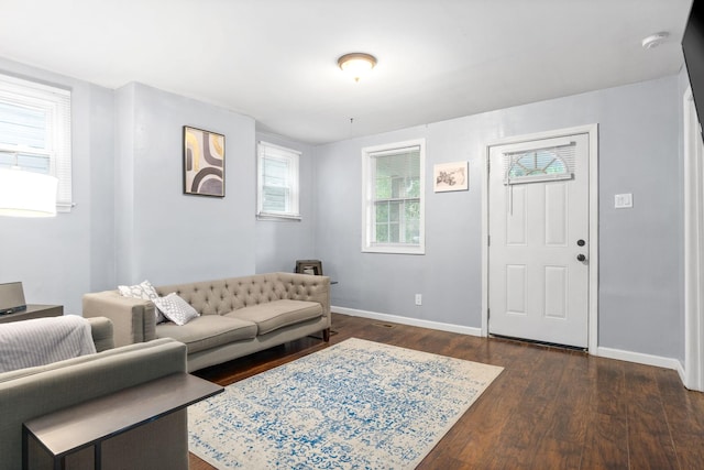 living room featuring dark wood finished floors, baseboards, and healthy amount of natural light