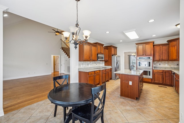 1015 Kingman Ave, Murfreesboro, TN 37129 - kitchen with stainless steel appliances, ornamental molding, decorative backsplash, a chandelier, and a kitchen island with sink