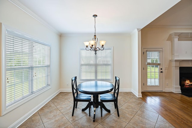 1015 Kingman Ave, Murfreesboro, TN 37129 - dining room with a chandelier, crown molding, a lit fireplace, light tile patterned floors, and baseboards