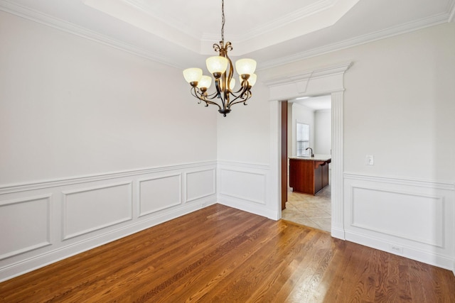 1015 Kingman Ave, Murfreesboro, TN 37129 - unfurnished room featuring a chandelier, wood finished floors, crown molding, a decorative wall, and wainscoting