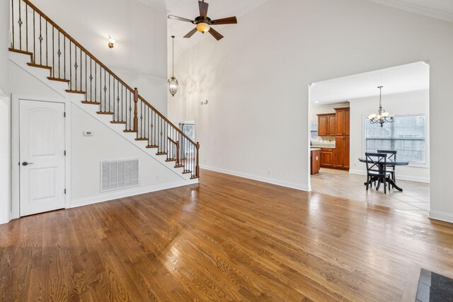 1015 Kingman Ave, Murfreesboro, TN 37129 - unfurnished living room with a chandelier, stairs, ceiling fan, light wood-style flooring, and baseboards