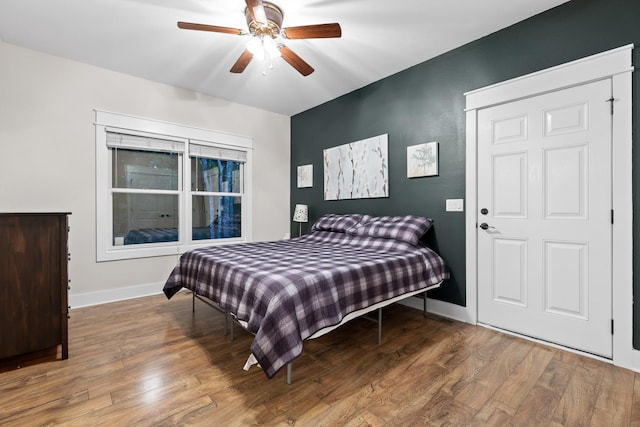 bedroom with wood finished floors, baseboards, and a ceiling fan