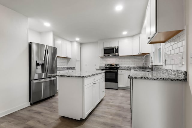 2851 Cooper Creek Rd, Woodlawn, TN 37191 - kitchen with stainless steel appliances, a sink, decorative backsplash, light wood finished floors, and light stone countertops