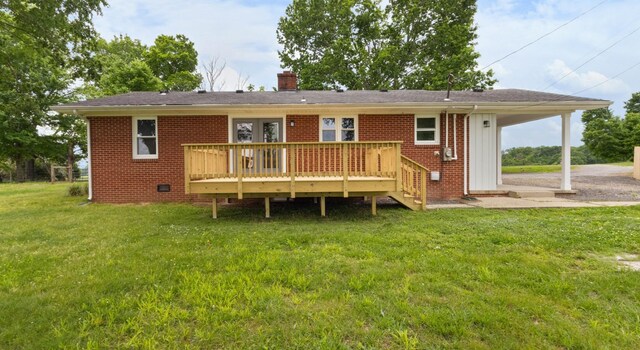 2851 Cooper Creek Rd, Woodlawn, TN 37191 - rear view of house featuring a deck, brick siding, a chimney, and a lawn