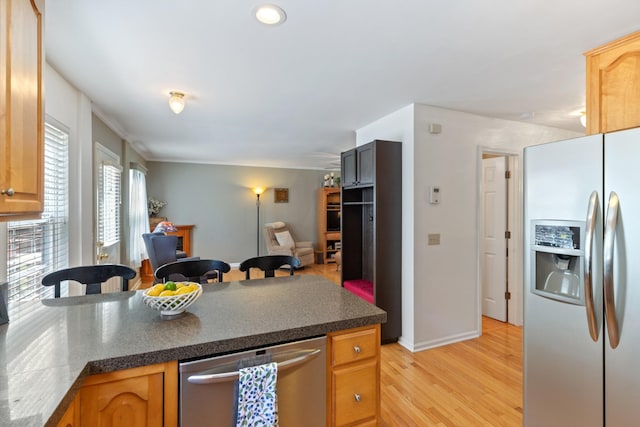 7104 Elrod Rd, Fairview, TN 37062 - kitchen featuring appliances with stainless steel finishes, dark countertops, a peninsula, open floor plan, and light wood-type flooring