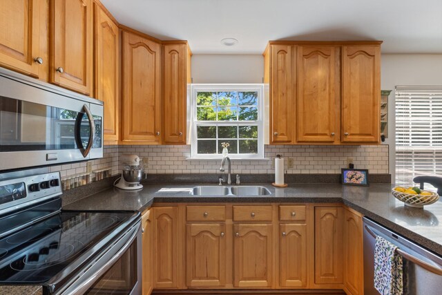 7104 Elrod Rd, Fairview, TN 37062 - kitchen featuring stainless steel appliances, a sink, decorative backsplash, and dark stone countertops