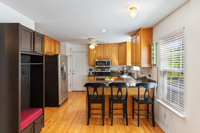 7104 Elrod Rd, Fairview, TN 37062 - kitchen with appliances with stainless steel finishes, a peninsula, light wood-style floors, decorative backsplash, and recessed lighting