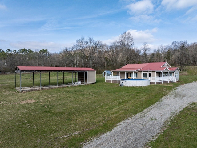 8310 Dog Creek Rd, Primm Springs, TN 38476 - rear view of property featuring an outdoor pool, a yard, a detached carport, and an outdoor structure
