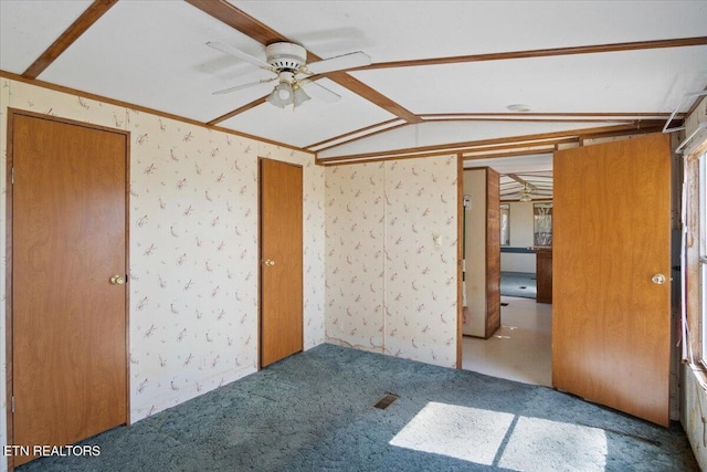 unfurnished bedroom with lofted ceiling, wallpapered walls, and carpet flooring
