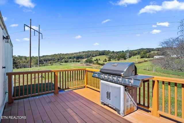 wooden deck featuring area for grilling and view of scattered trees