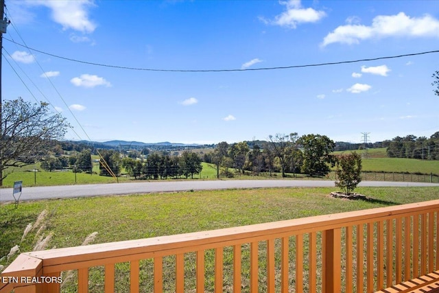 wooden deck with a mountain view and a lawn