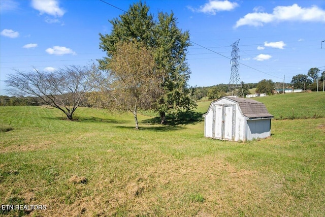 view of green lawn with a shed and an outbuilding