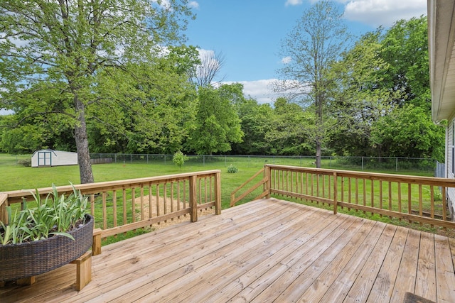 deck featuring a shed, an outdoor structure, and view of scattered trees