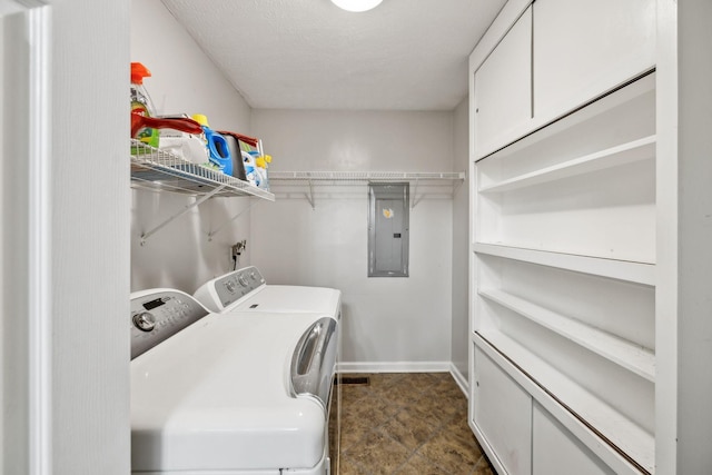 laundry room featuring electric panel, separate washer and dryer, and baseboards