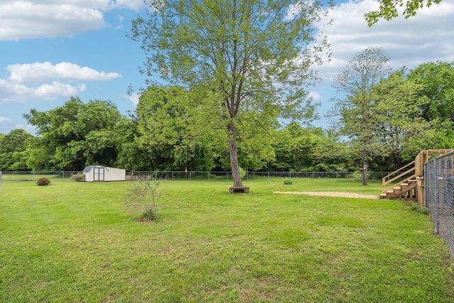 view of yard featuring a storage shed, an outdoor structure, and stairs