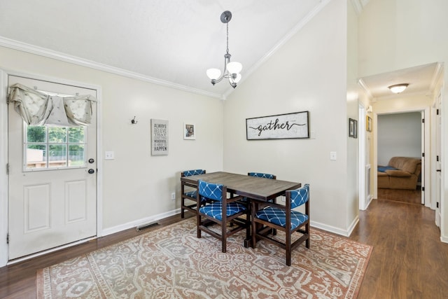 dining area with lofted ceiling, crown molding, wood finished floors, a chandelier, and baseboards
