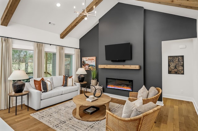 living room with high vaulted ceiling, beamed ceiling, baseboards, a glass covered fireplace, and a chandelier