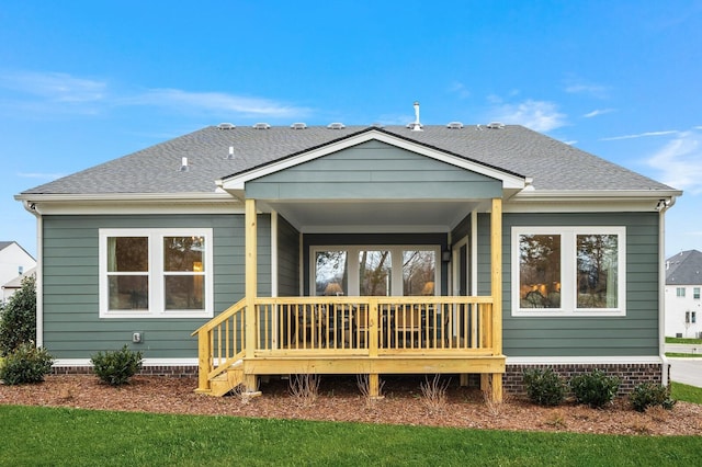 rear view of property with a shingled roof and a porch