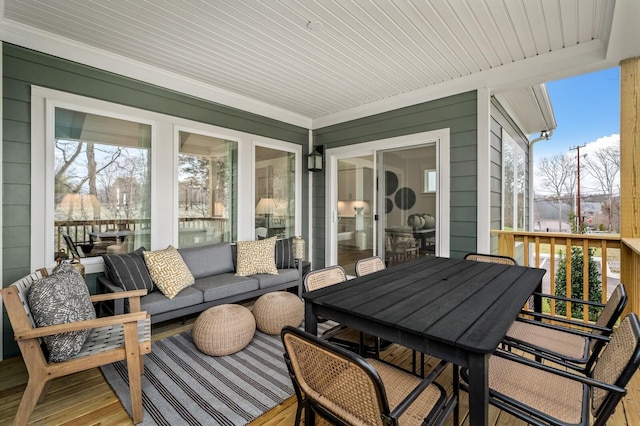 sunroom / solarium featuring healthy amount of natural light and outdoor dining area