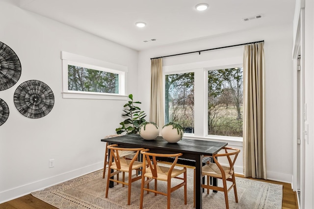 dining space featuring baseboards, wood finished floors, and recessed lighting