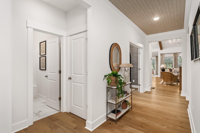 hallway featuring baseboards, crown molding, and recessed lighting