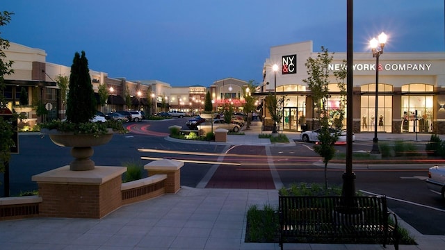 view of asphalt street with sidewalks, street lighting, and curbs