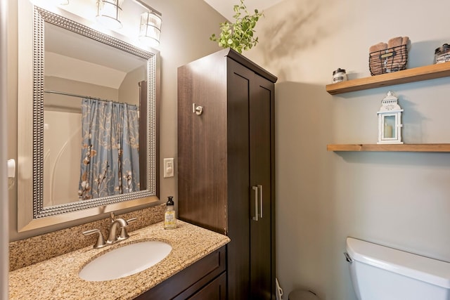 bathroom featuring toilet, vanity, and a shower with shower curtain