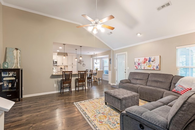 living area with a ceiling fan, dark wood finished floors, crown molding, baseboards, and vaulted ceiling