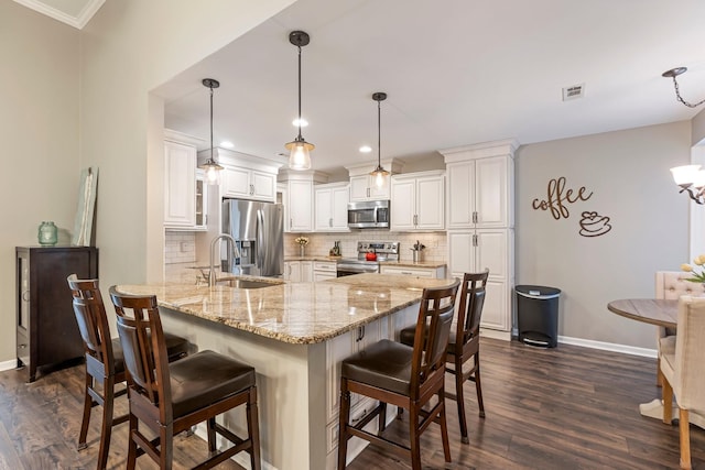 kitchen featuring stainless steel appliances, a sink, a peninsula, dark wood-style flooring, and baseboards