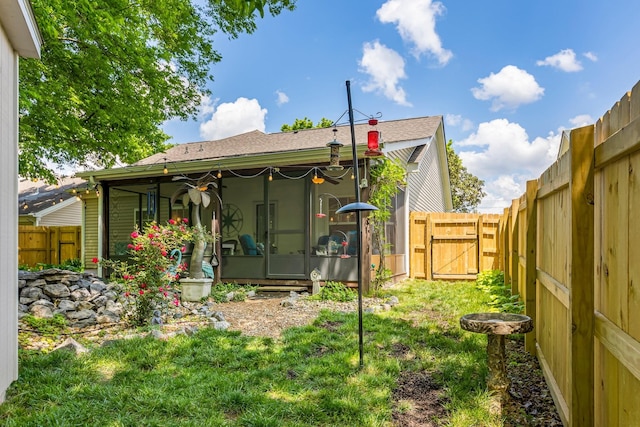 rear view of property with a sunroom, a gate, and a shingled roof