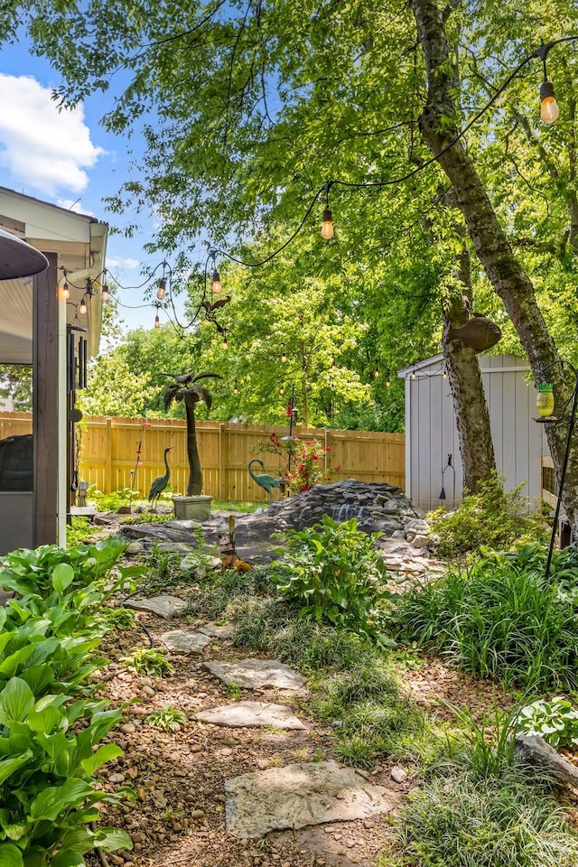 view of yard with a storage shed, fence, and an outdoor structure