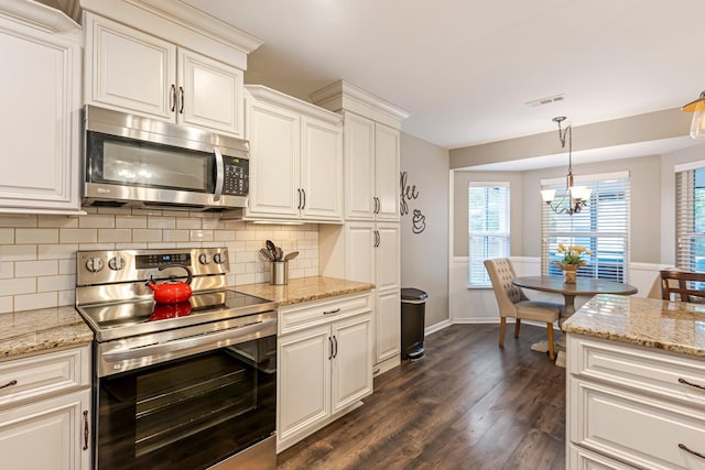 kitchen with appliances with stainless steel finishes, dark wood-style floors, tasteful backsplash, pendant lighting, and a chandelier