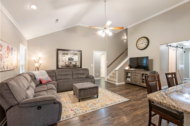 living room with a barn door, ornamental molding, ceiling fan, dark wood-style flooring, and stairway