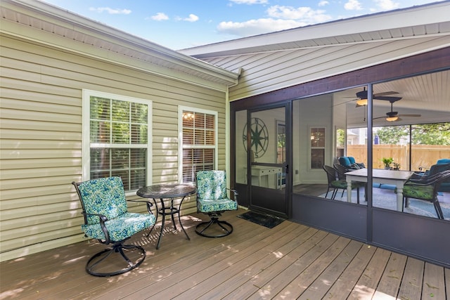 wooden terrace with a ceiling fan and fence