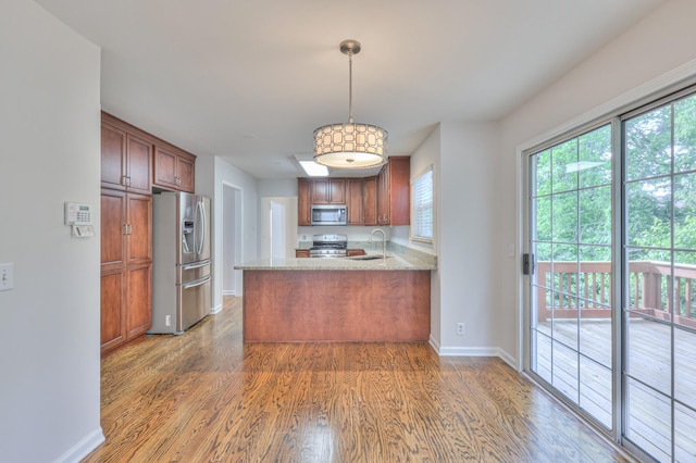 408 Parish Pl, Franklin, TN 37067 - kitchen with stainless steel appliances, wood finished floors, baseboards, a peninsula, and pendant lighting