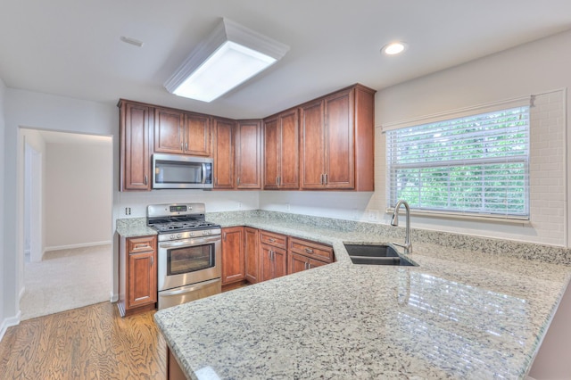 408 Parish Pl, Franklin, TN 37067 - kitchen with appliances with stainless steel finishes, a sink, light wood-type flooring, light stone countertops, and recessed lighting