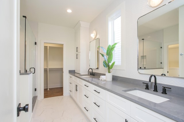 431B Basswood Ave, Nashville, TN 37209 - full bath featuring marble look tiles, a walk in closet, double vanity, a stall shower, and baseboards