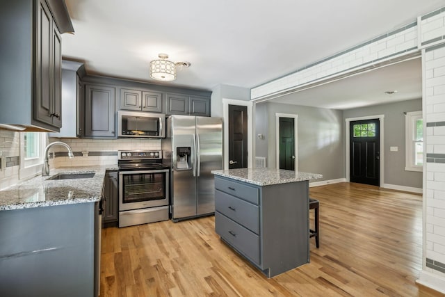 4408 Alpine Way, Murfreesboro, TN 37129 - kitchen featuring appliances with stainless steel finishes, a sink, backsplash, a kitchen breakfast bar, and light wood-style floors