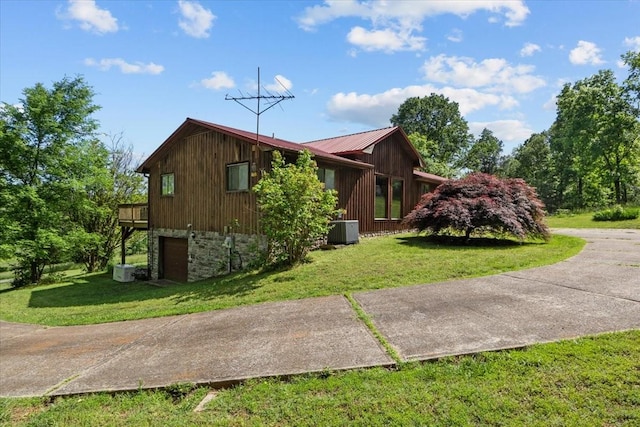4410 Trace Creek Rd, Mc Ewen, TN 37101 - view of property exterior with cooling unit, a garage, a lawn, and metal roof